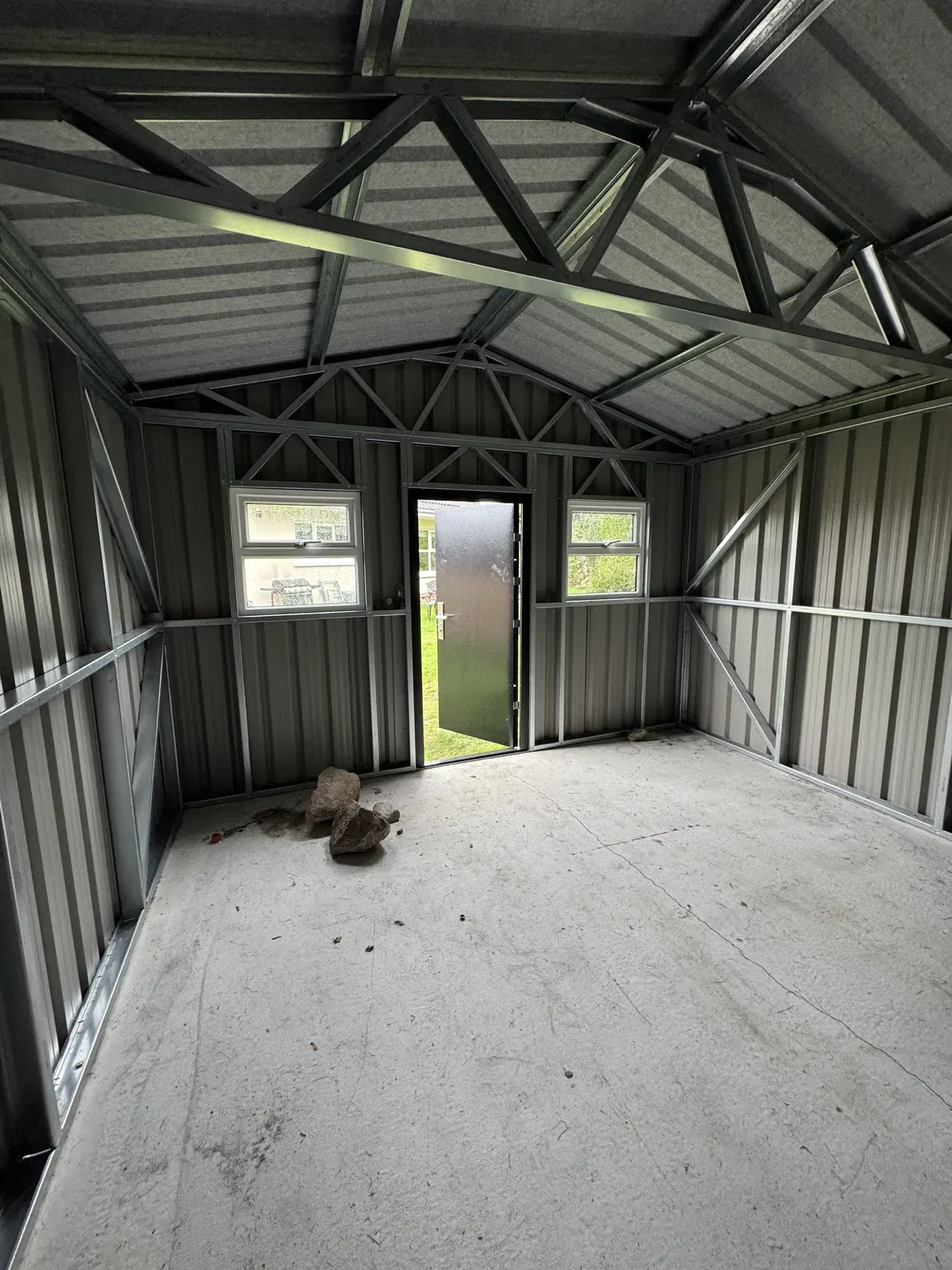 Inside a galvanised steel shed showing the roof trusses